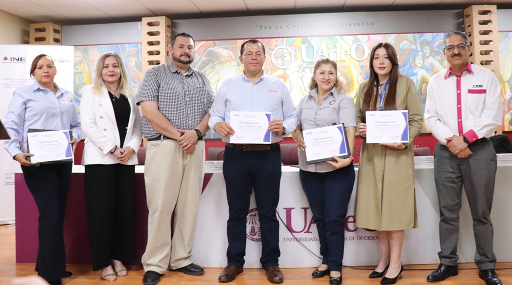 siete personas de pie sosteniendo diplomas