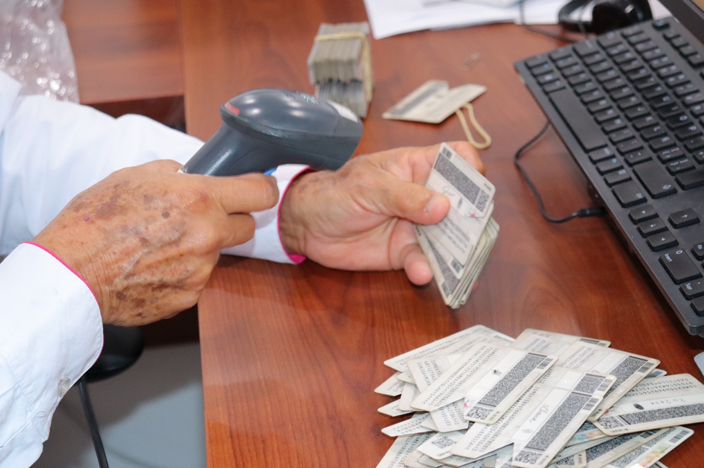 una persona colocando un lector de código QR sobre una credencial para votar