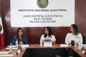 tres mujeres sentadas frente a una mesa con micrófonos