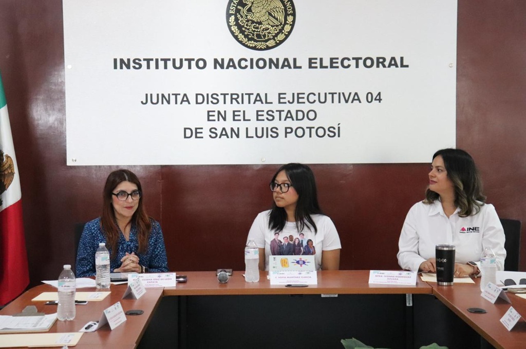 tres mujeres sentadas frente a una mesa con micrófonos