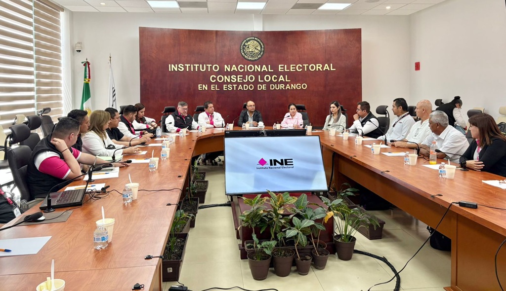 varias personas sentadas alrededor de una mesa de madera ovalada