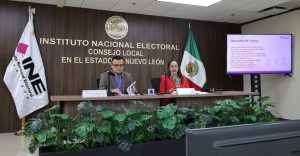 una mujer y un hombre sentados frente a un micrófono