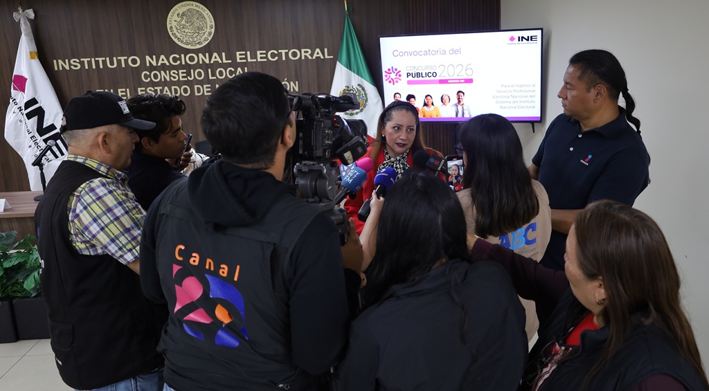 mujer rodeada de personas con cámaras y micrófonos