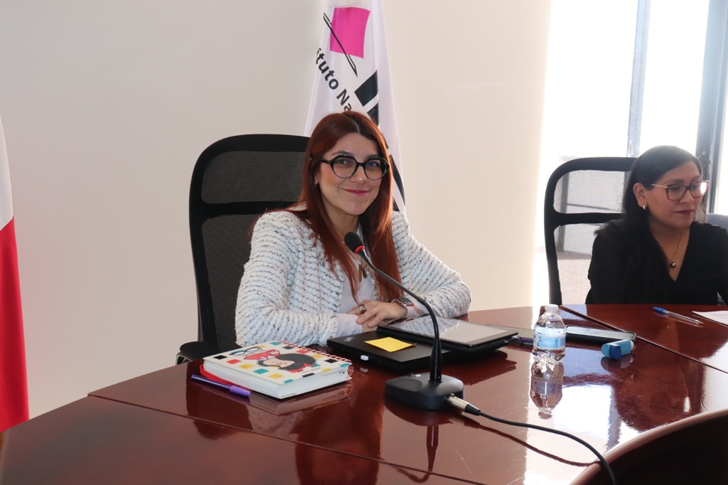 mujer pelirroja sentada frente a un micrófono