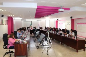 varias mujeres sentadas en una mesa ovalada