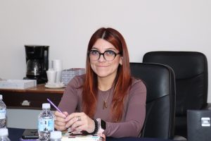 Mujer de cabello rojizo sentada sonriendo