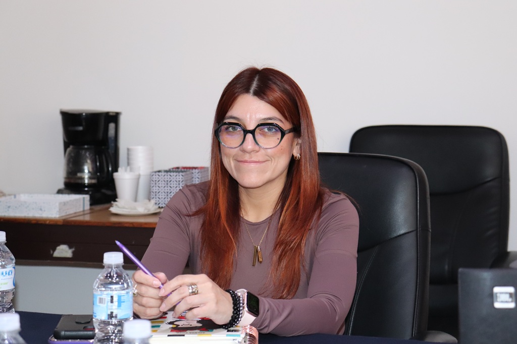 Mujer de cabello rojizo sentada sonriendo