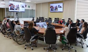 personas en sillas de ruedas en una Sala de Juntas del INE