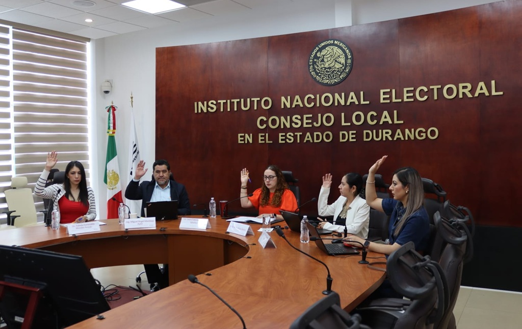 cinco personas sentadas votando a mano alzada