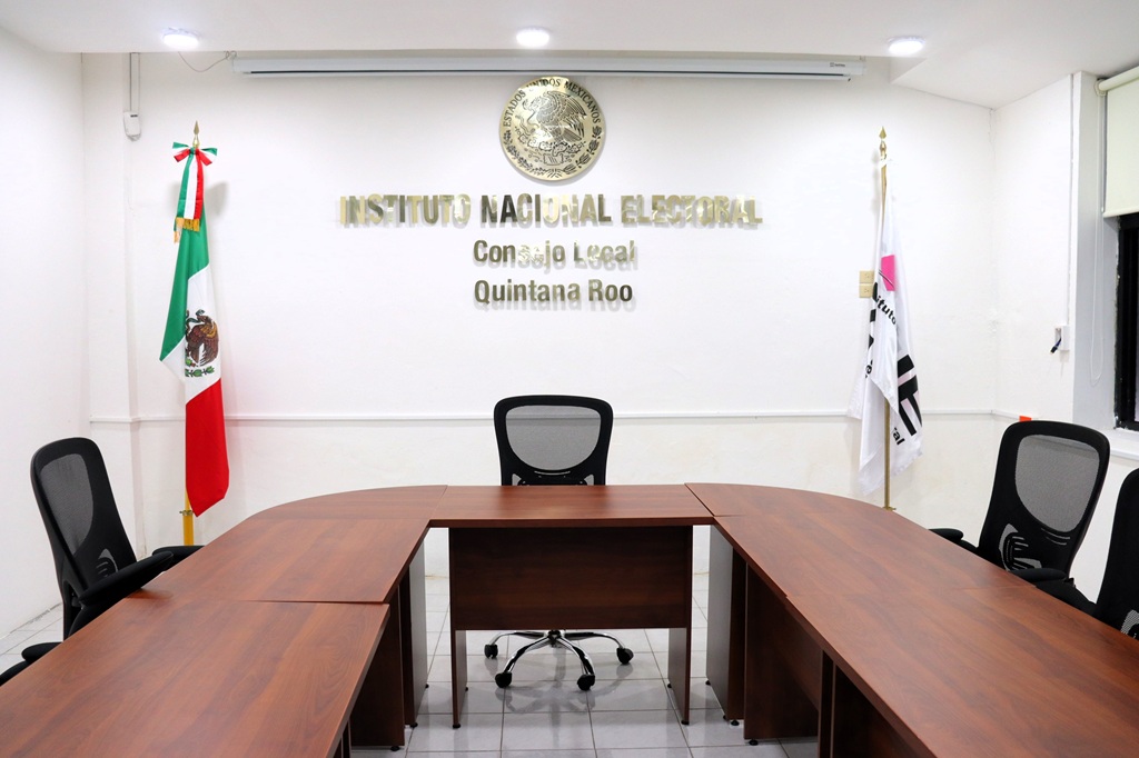 un salón con sillas y una mesa semiovalada
