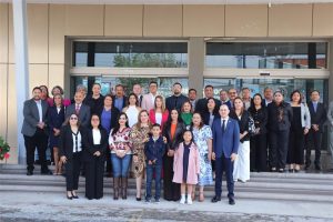 muchas personas adultas y dos menores de edad de pie en unas escaleras para foto oficial