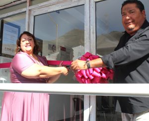 una mujer y un hombre sosteniendo un listón rosa