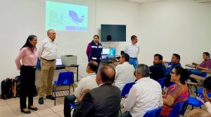 cuatro personas hablando frente a varias personas sentadas