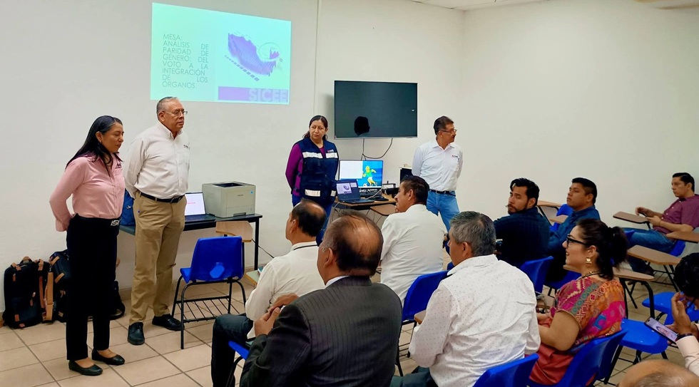 cuatro personas hablando frente a varias personas sentadas