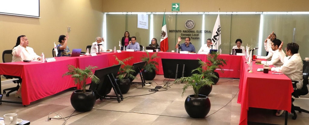 personas sentadas votando a mano alzada