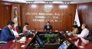 cinco personas sentadas alrededor de una mesa de madera