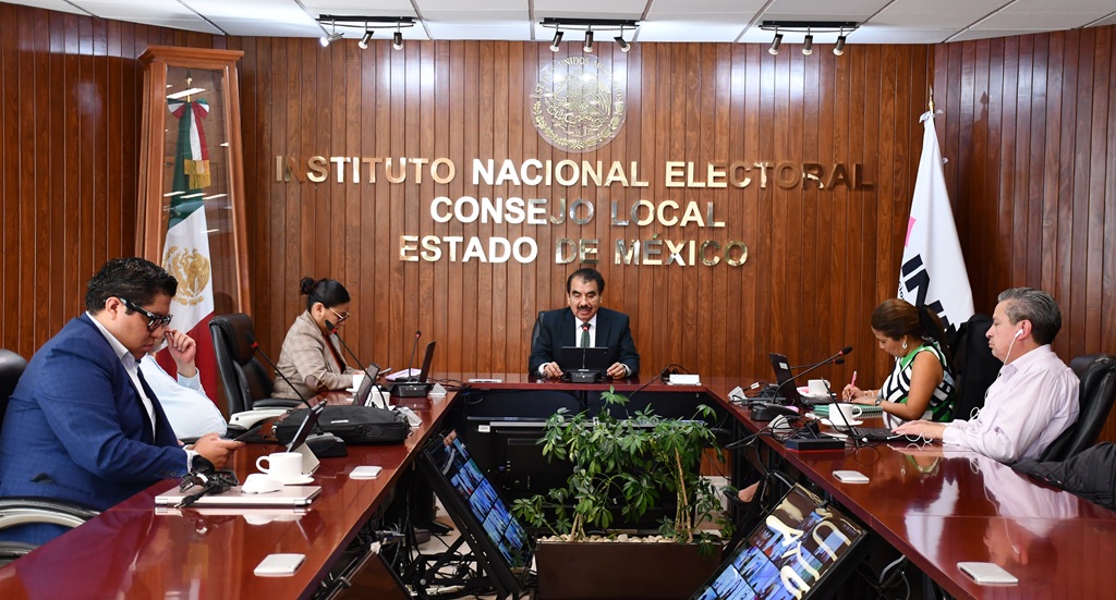 cinco personas sentadas alrededor de una mesa de madera