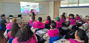 varias personas con chalecos rosa y letras INE sentados en un salón