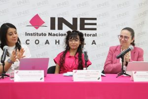 tres mujeres sentadas, dos de ellas aplauden