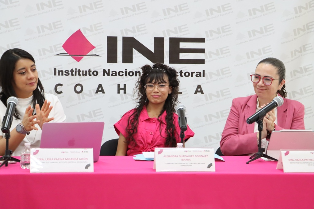 tres mujeres sentadas, dos de ellas aplauden