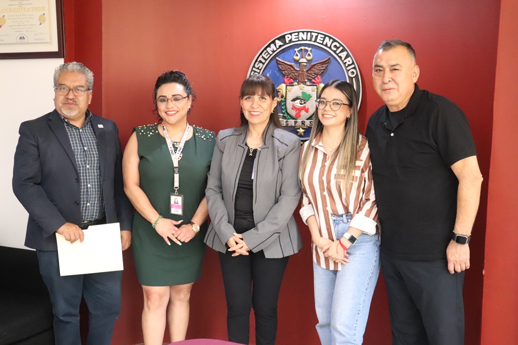 tres mujeres y dos hombres de pie para la foto oficial