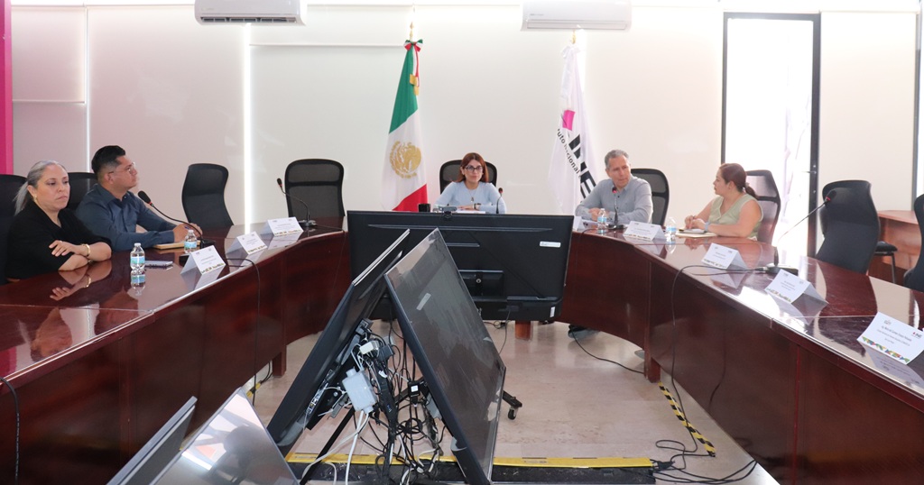 seis personas sentadas alrededor de una mesa, semi-ovalada