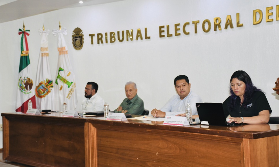 tres personas sentadas frente a una mesa de madera