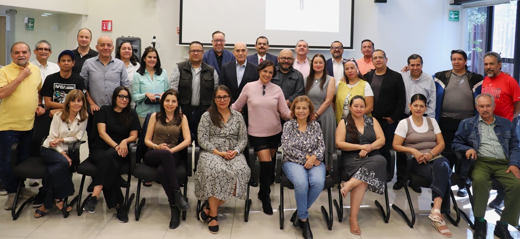 más de 20 personas sentadas y de pie posando para la foto