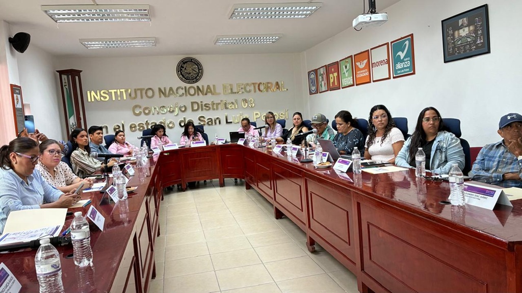 más de 10 mujeres sentadas alrededor de una mesa de madera