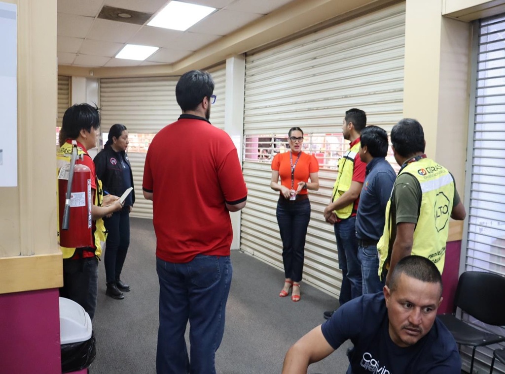 siete personas escuchando a una mujer que habla