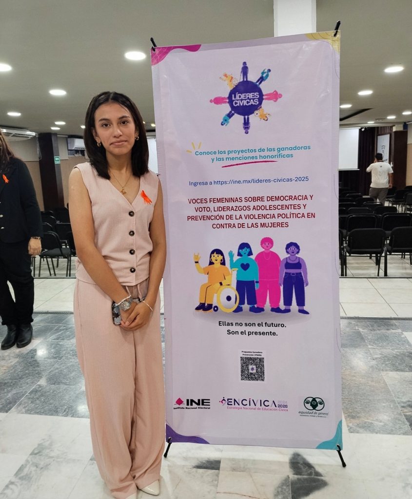 una adolescente de pie a un costado de una lona vertical