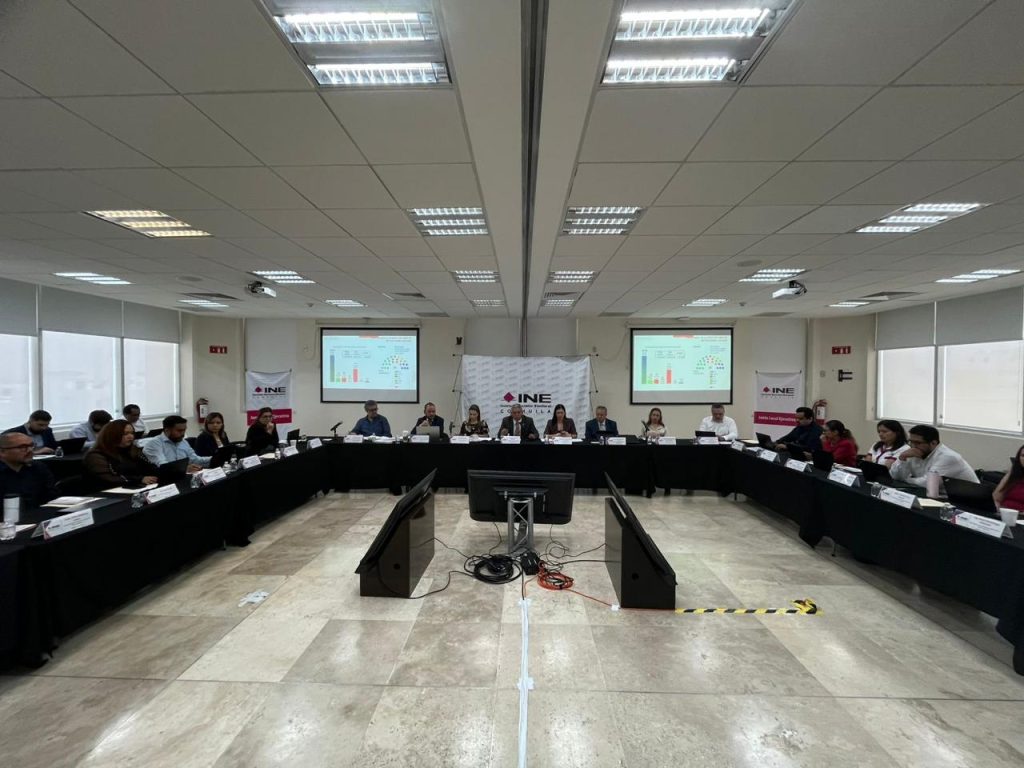 Personas participantes sentadas en el salón.