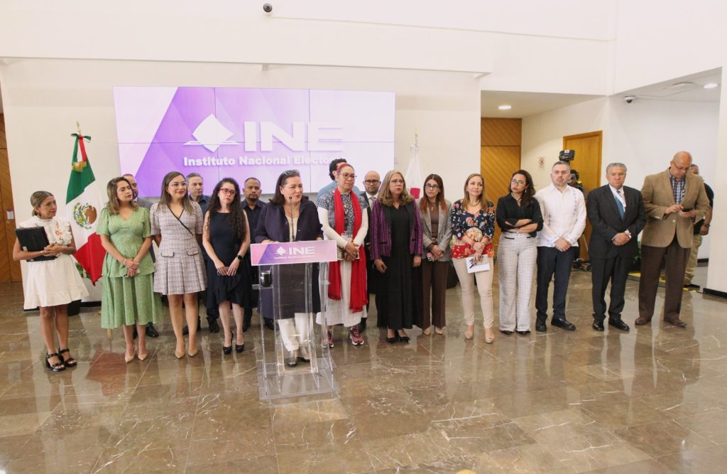 Funcionarios del Instituto parados enfrente del os medios de comunicación en el lobby.