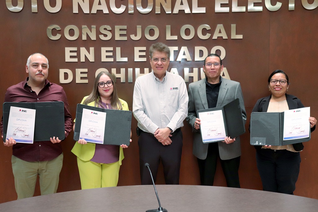 cinco personas de pie, están sosteniendo un diploma