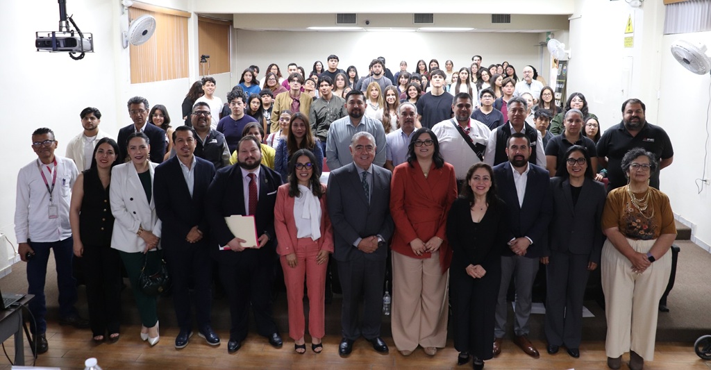 Varias personas de pie en un auditorio en la fotografía oficial