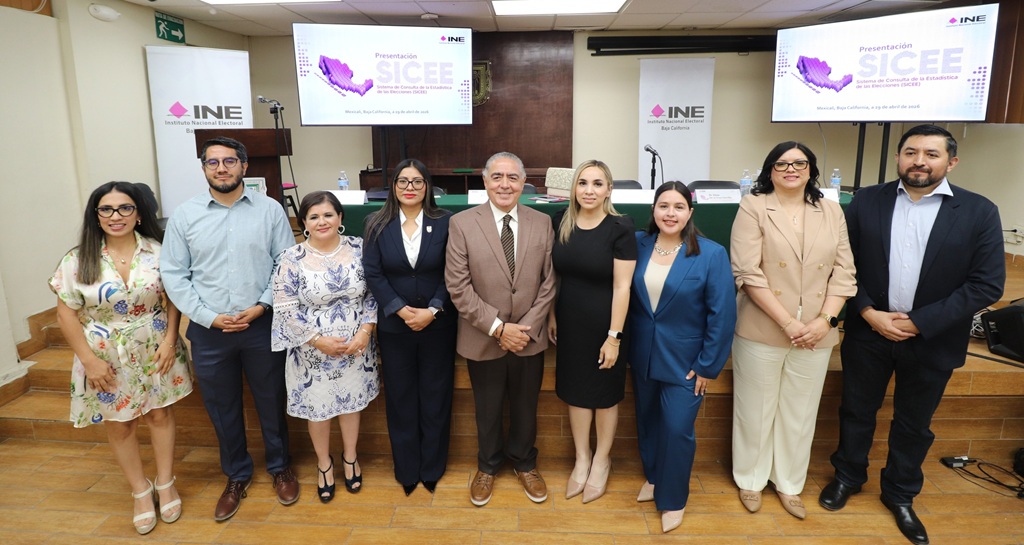 nueve personas de pie posando para la foto oficial
