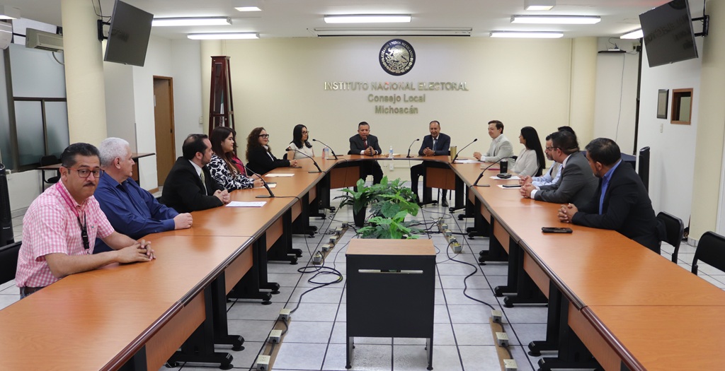 varias personas sentadas alrededor de una mesa rectangular