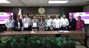 diez personas de pies mientras muestran un diploma