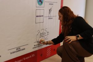 una mujer firmando una pared