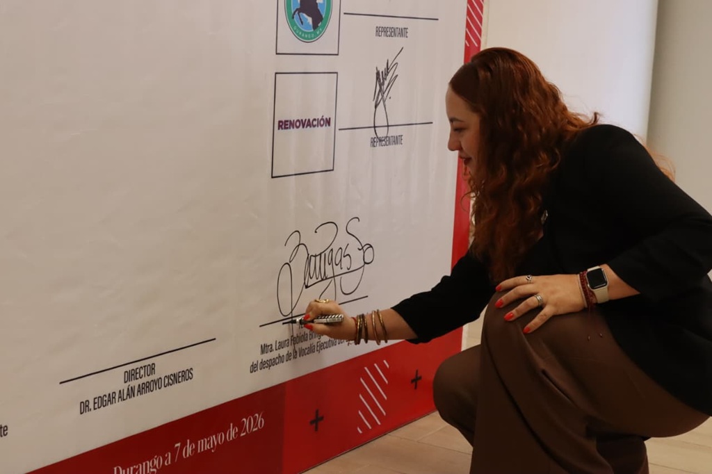 una mujer firmando una pared