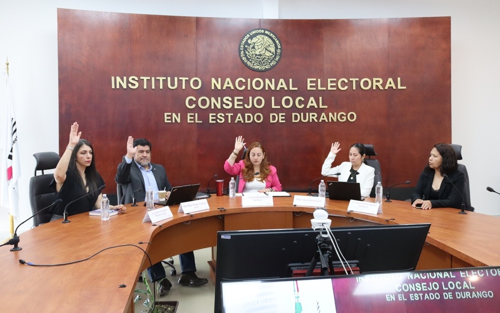 cinco personas sentadas votando a mano alzada