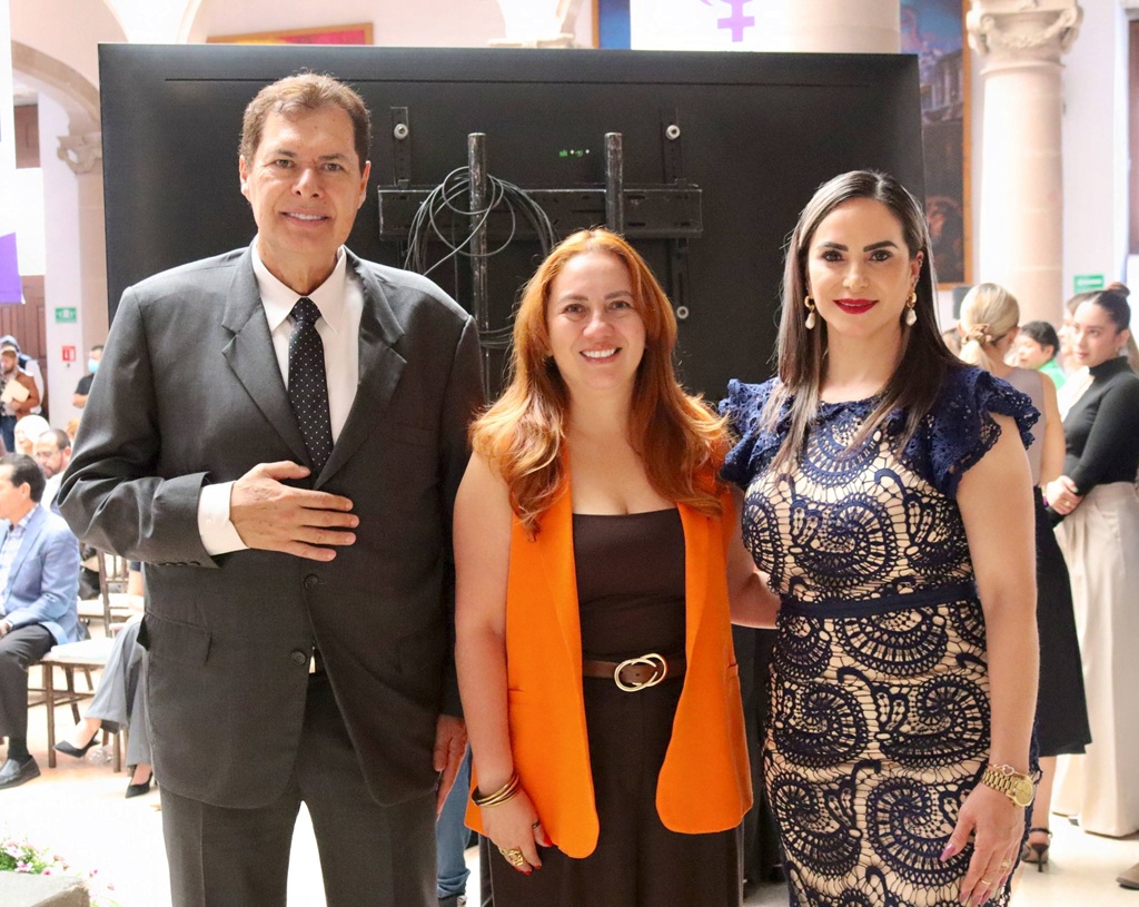 Dos mujeres y un hombre de pie posando para la foto oficial
