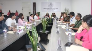 varias personas sentadas en una sala de juntas