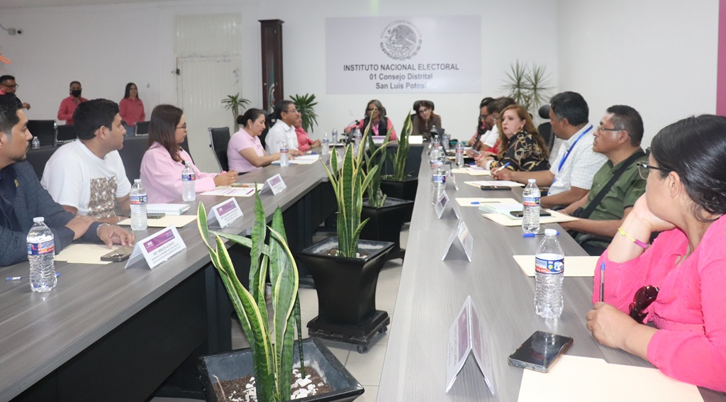 varias personas sentadas en una sala de juntas