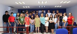 veinte personas reunidas de pie posando para la fotografía