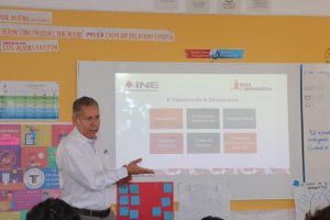 un hombre de pie dando una clase a estudiantes