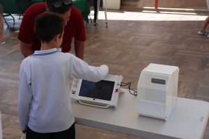 un infante usando la urna electrónica de votación