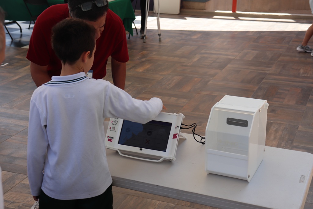 un infante usando la urna electrónica de votación