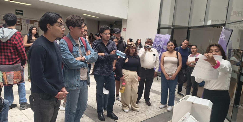 una persona explicando el funcionamiento de una maquina a estudiantes