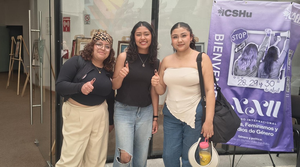 Tres estudiantes mostrando su pulgar en señal de que ya votaron